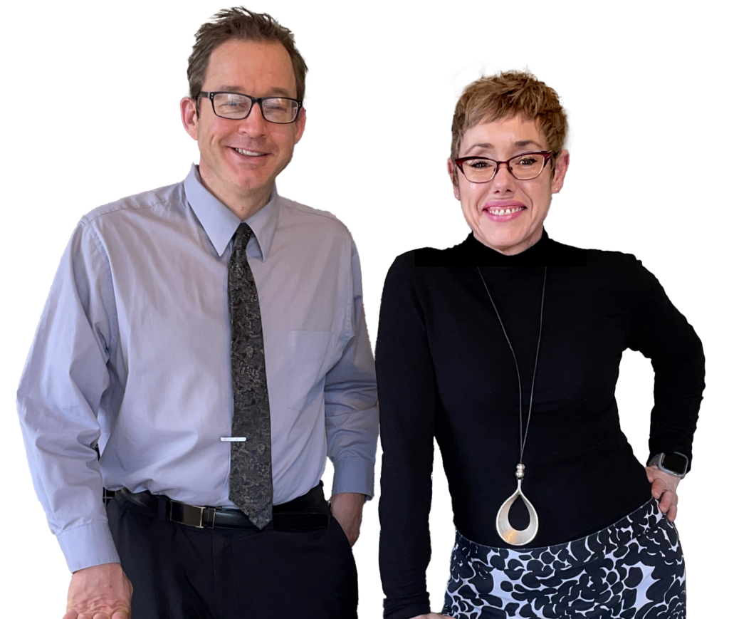 Two smiling professionals posing against a white background. Man on left wears light blue shirt and dark tie. Woman on right wears black top with patterned pants and pendant necklace.
